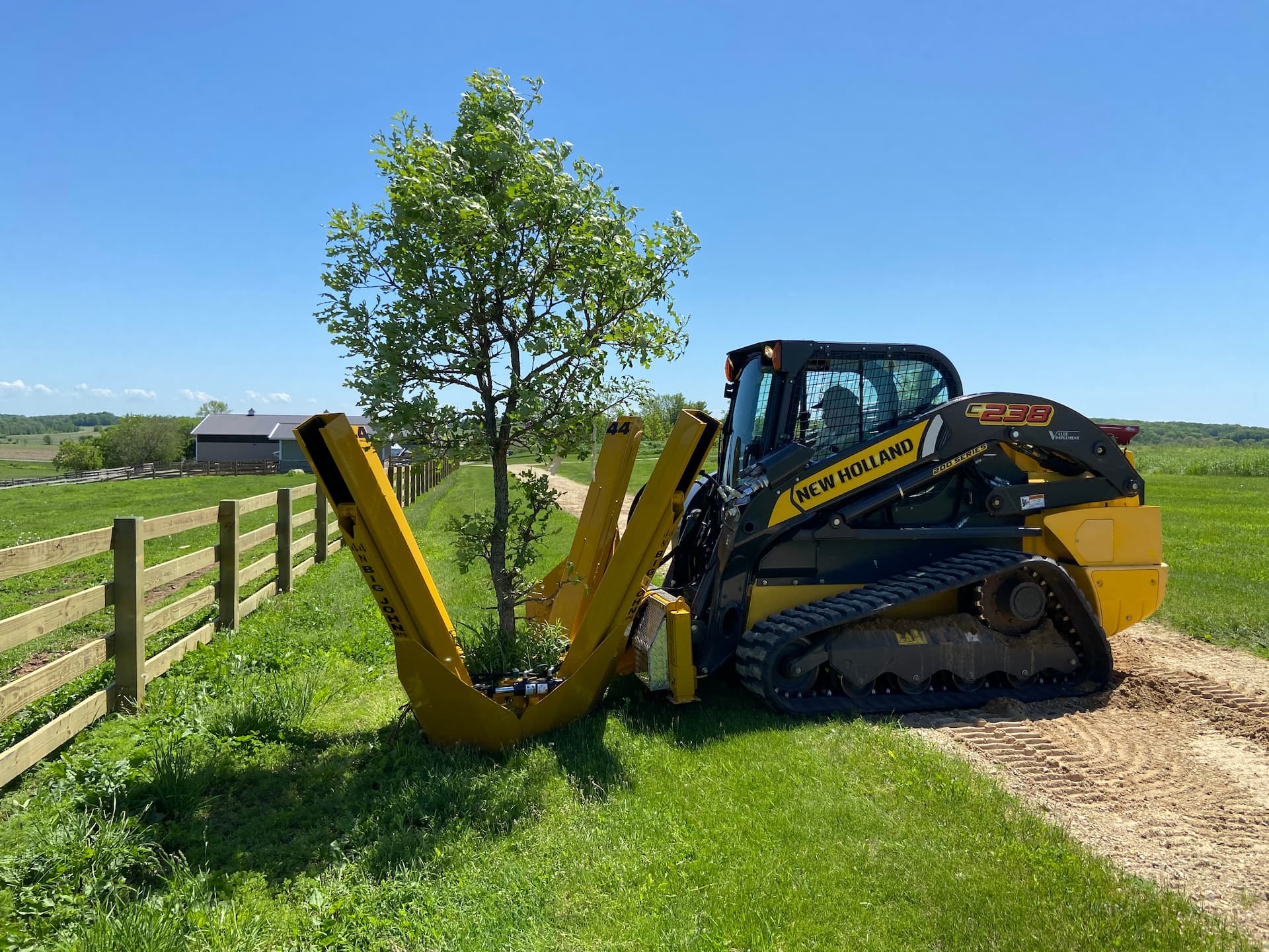 44-skidsteer tractor with tree spade attached ready to transplant tree